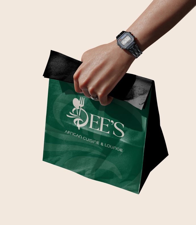A hand carrying a green Dee's takeaway bag